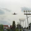 Vliegtuig vliegt boven huizen in de buurt van landingsbaan